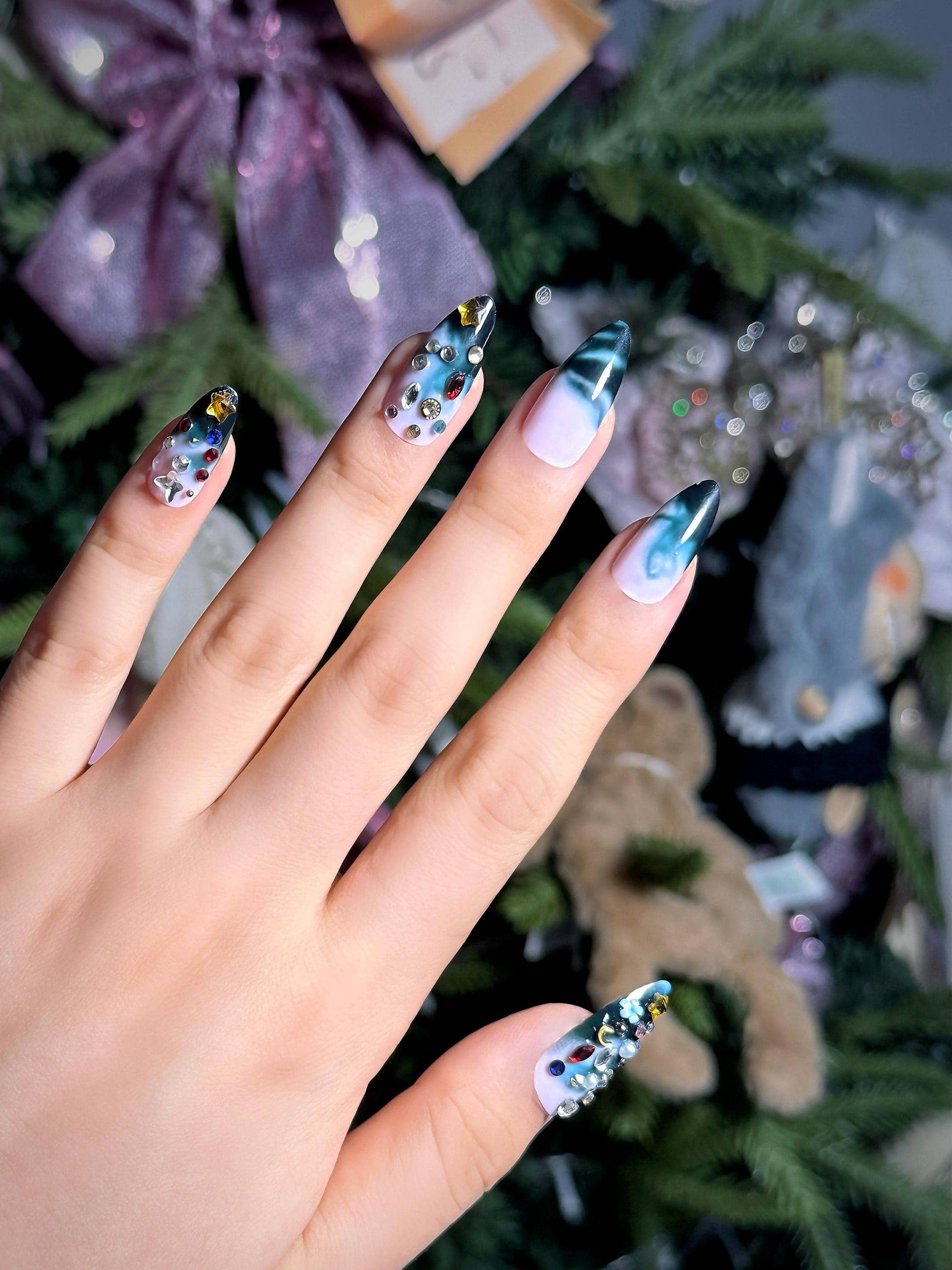 Ombre blue press on nails with colorful gem embellishments, featuring a gradient design perfect for holiday parties, office and daily use. Medium length almond shape fake nails with a bold, eye-catching style.