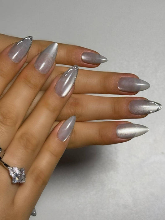 Clean girl silver cat eye press on nails with luminous shimmery finish and subtle metallic tip accents. Perfect for daily use, office, dates and holidays. Medium length almond shape fake nails with an effortlessly chic, minimalist design.