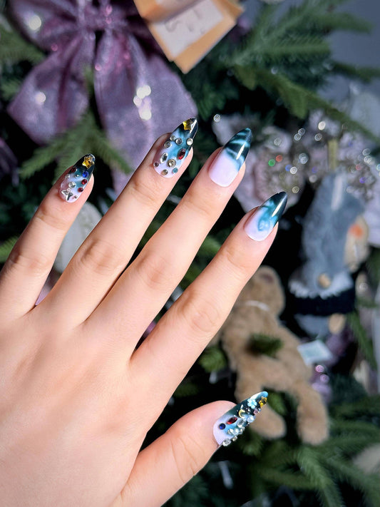 Ombre blue press on nails with colorful gem embellishments, featuring a gradient design perfect for holiday parties, office and daily use. Medium length almond shape fake nails with a bold, eye-catching style.