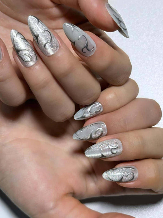 Swirl silver line white cat eye press on nails with a shimmery finish. Perfect for daily use, office, parties and holidays. Medium length almond shape fake nails with a sleek, futuristic vibe.
